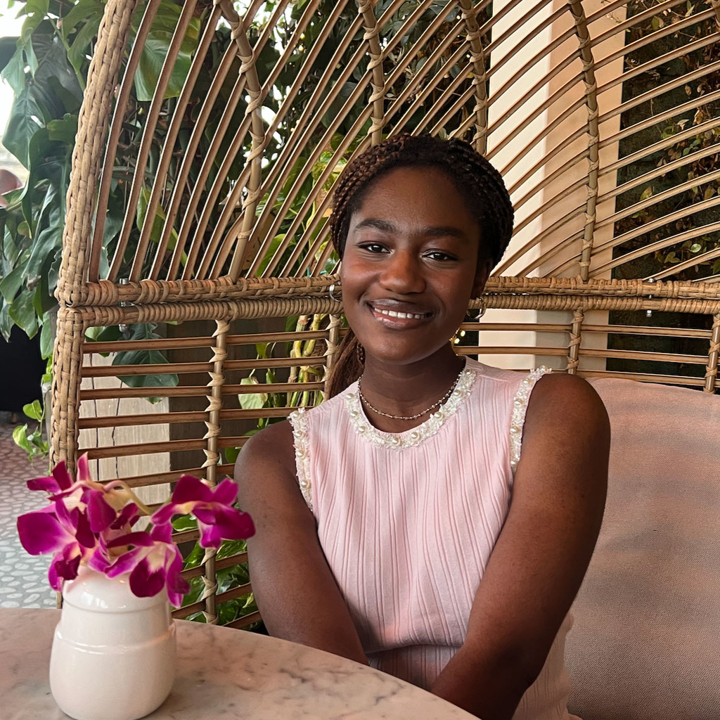 Richelle Fenteng sitting at table with pink orchids in vase